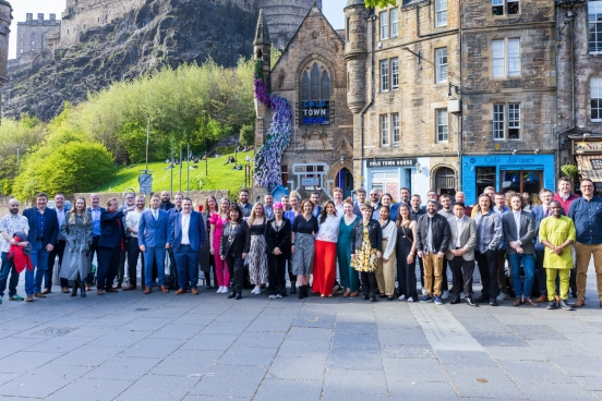 Une photo d’une cinquantaine d’employés de Forrit debout dehors au soleil à Édimbourg
